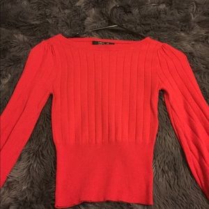 Cropped red ribbed sweater with balloon sleeves.
